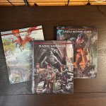 Left to right C&C books: Monsters & Treasure (with a montage of classic creatures), Players Handbook (a party cleaning up and looting a temple after a fight), and Castle Keeper Guide (An Efreet attacking the party).