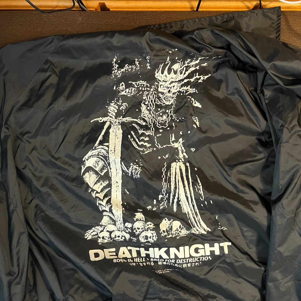 A skeletal warrior in chainmail and wielding a sword. He is crouched over skulls.