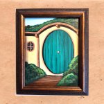 A path leading to a round hobbit door.