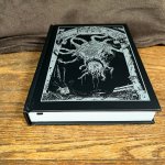 Product shot of Shadowdark, with a gruesome beast on the front cover in silver.