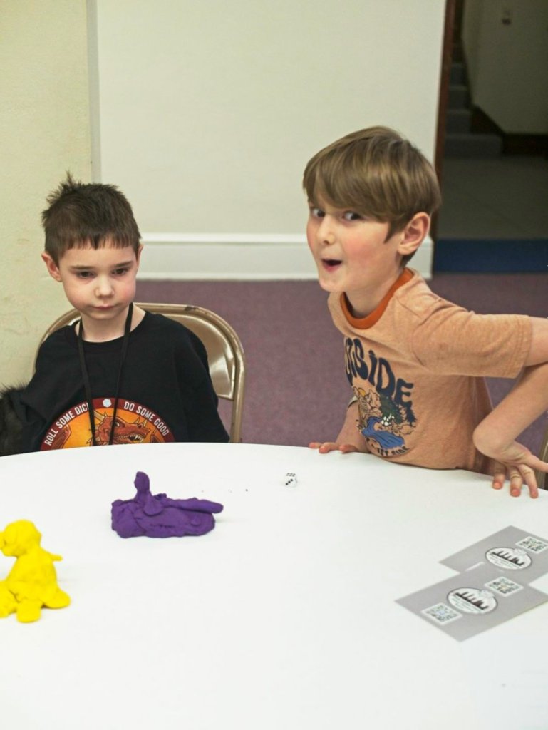 A young player plans something hilarious while a friend looks on.