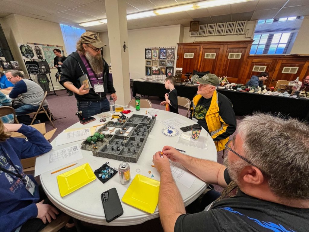 Players at a circular table discuss how to make their next move.