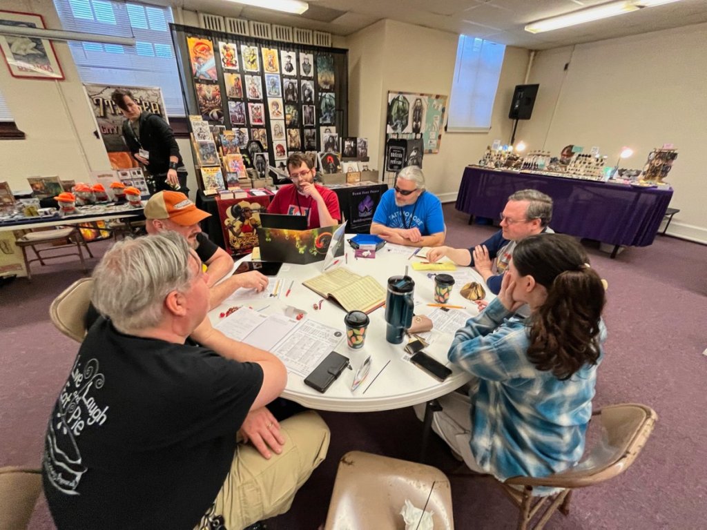 Players at a circular table discuss how to make their next move.