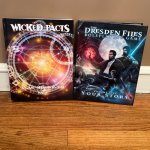 Wicked Pacts and The Dresden Files rulebooks standing next to each other.